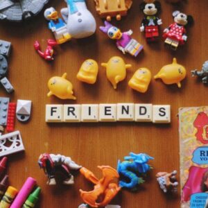 Scrabble tiles spelling 'Friends' are surrounded by toys. Toys, like other OT resources, can help children with autism or ADHD develop social skills.